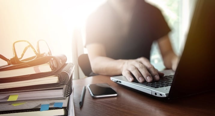 designer hand working with  digital tablet and laptop and notebook stack and eye glass on wooden desk in office.jpg